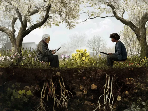 An elder and a young person sit across each other, both mutually apprenticing and leading each other in keeping with the apprenticeship leadership model.